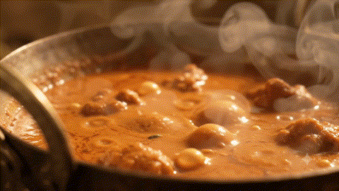 Butter chicken being prepared in a pan